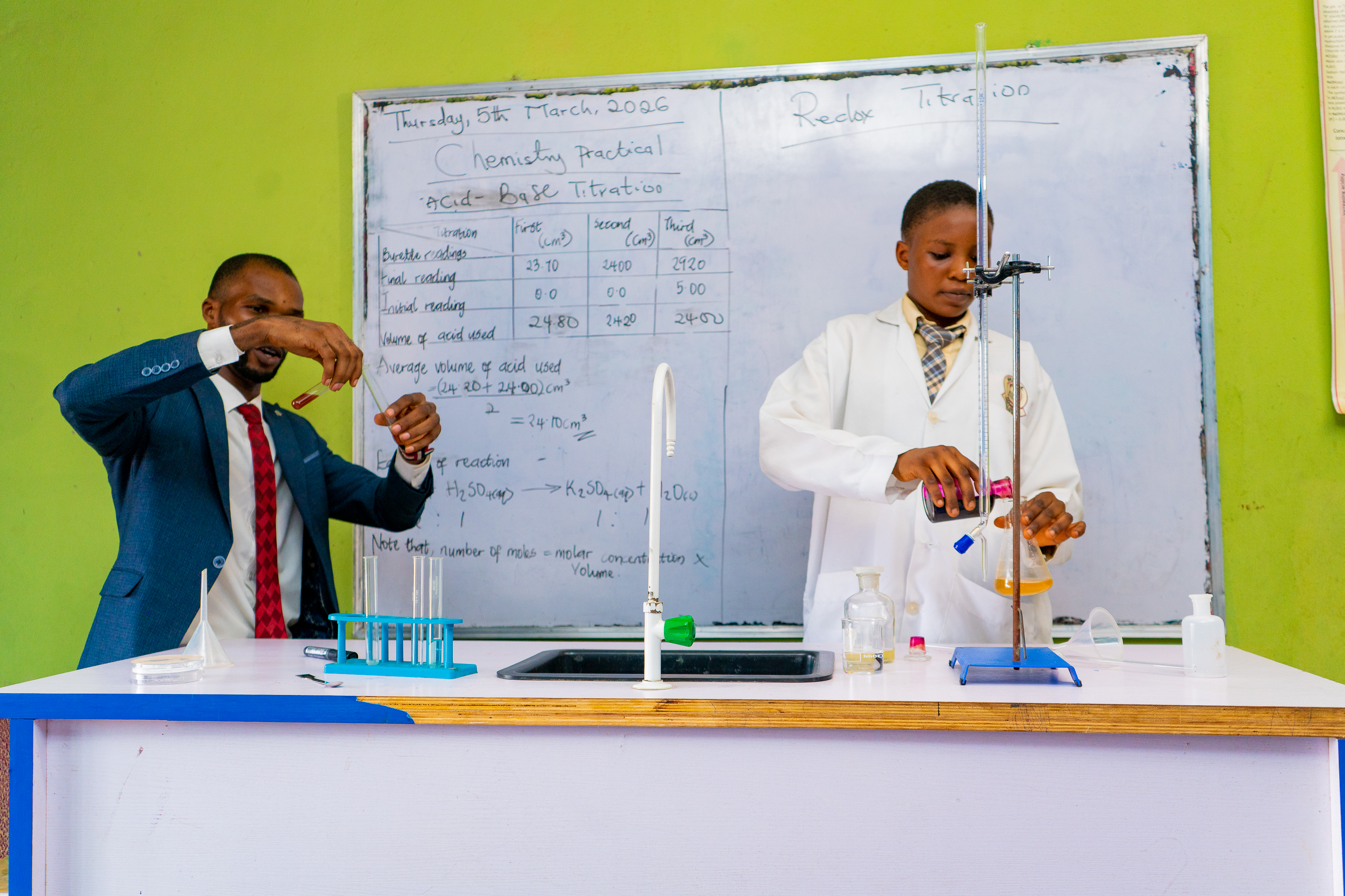 A male teacher and a female student during a chemistry practical session