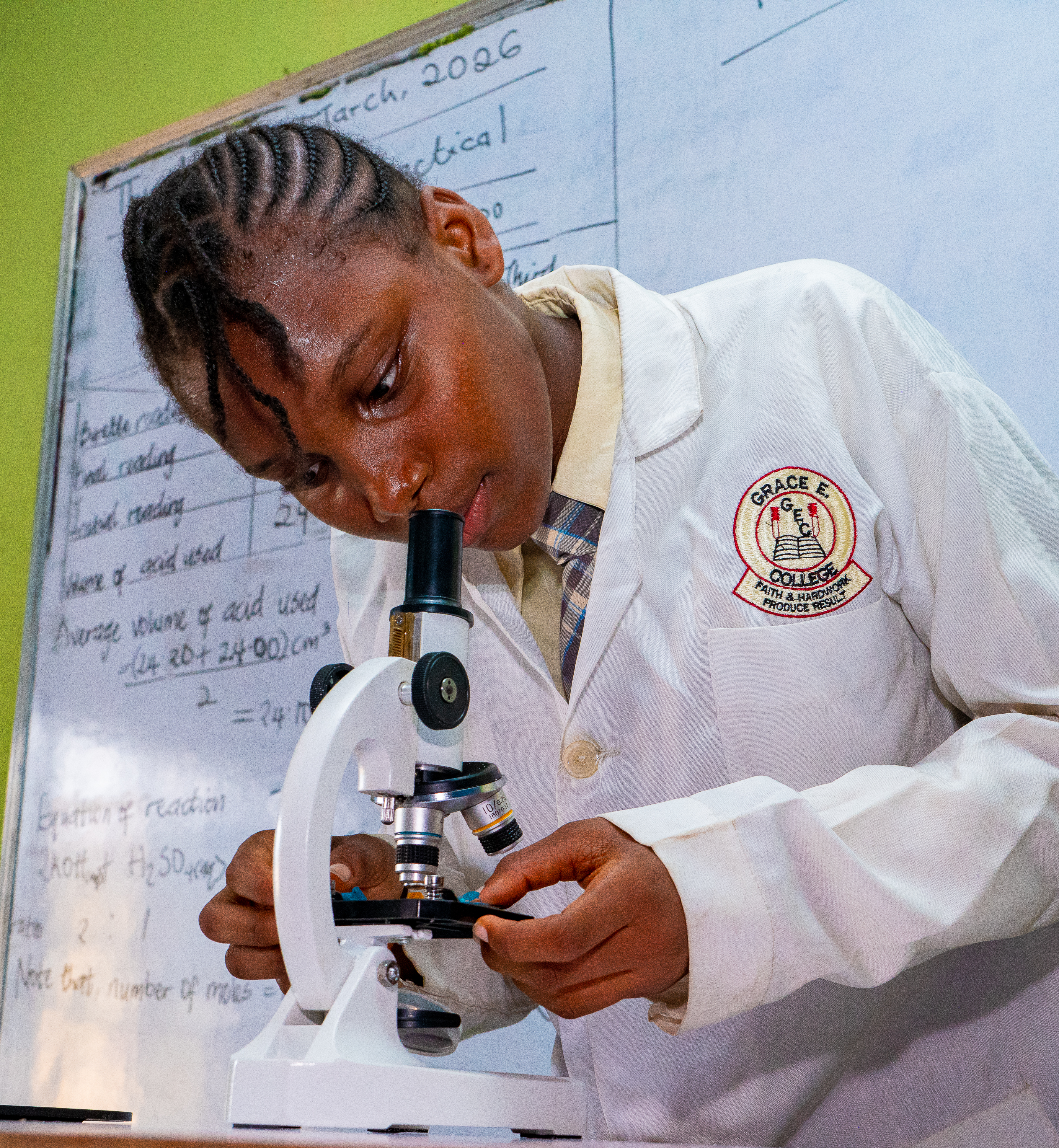A female college student setting up a microscope in the science laboratory