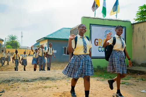 Two female college students walking away from the school gate