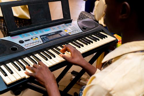 Backview of a male college student playing the keyboard