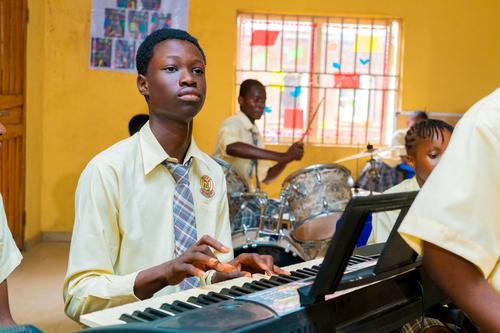 A male college student playing the keyboard
