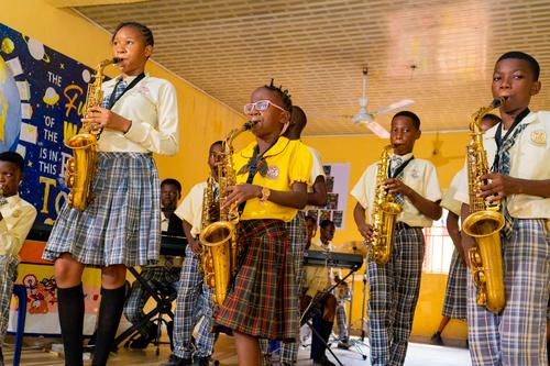 College and primary students playing the saxophone during music class