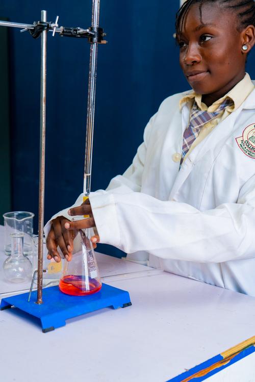 A female college student carrying out an acid-base reaction in the chemistry laboratory