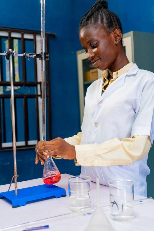 A female college student carrying out an acid-base reaction in the chemistry laboratory