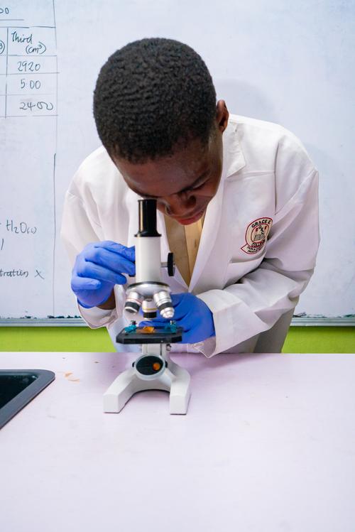Student viewing specimen through microscope