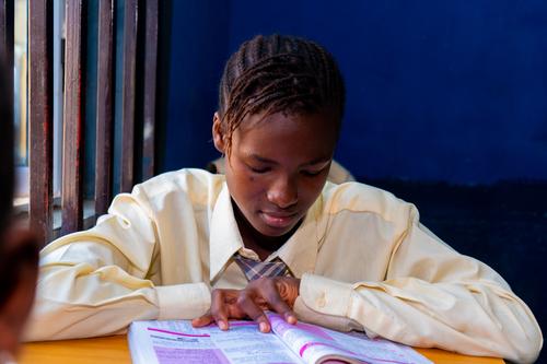 A female college student reading in the classroom
