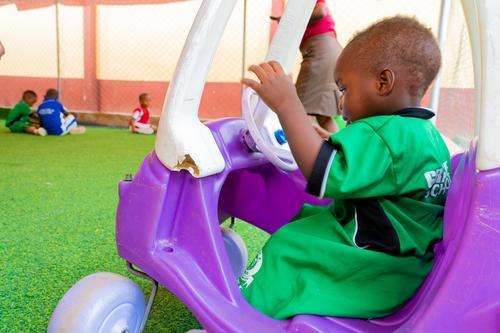 Nursery child on a car toy on the playground