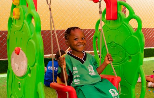 Nursery child on a swing on the playground