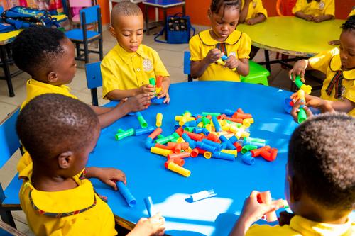 Nursery pupils interacting with pipe building blocks in the classroom