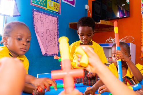 Nursery pupils interacting with pipe building blocks in the classroom