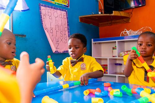 Nursery pupils interacting with pipe building blocks in the classroom