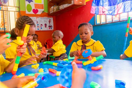Nursery pupils interacting with pipe building blocks in the classroom