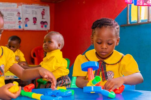 Nursery pupils interacting with pipe building blocks in the classroom