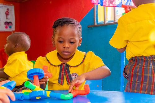 Nursery pupils interacting with pipe building blocks in the classroom
