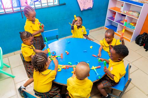 Nursery pupils interacting with pipe building blocks in the classroom