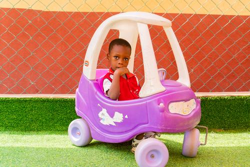 Nursery child on a car toy on the playground