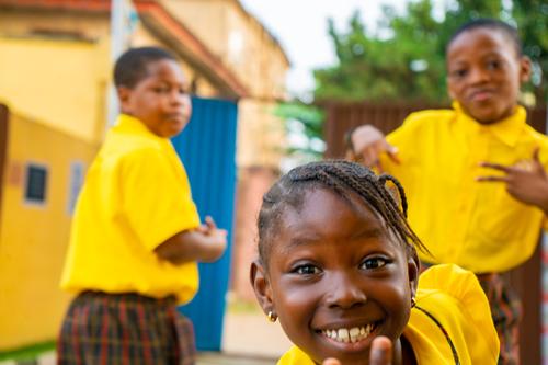 A female primary pupil smiling on the playground