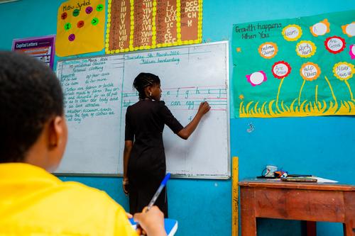 Female teacher writing on a whiteboard