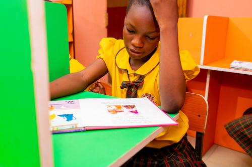 A female primary pupil studying in the school library