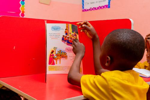 Side view of a male primary pupil in the school library
