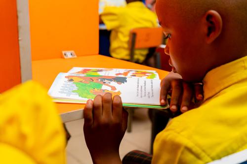 A male primary pupil reading in the school library