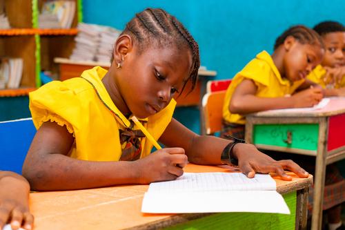 A female primary pupil writing in the classroom