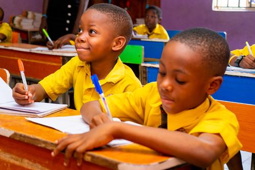 Pupils at their desks writing in the classroom